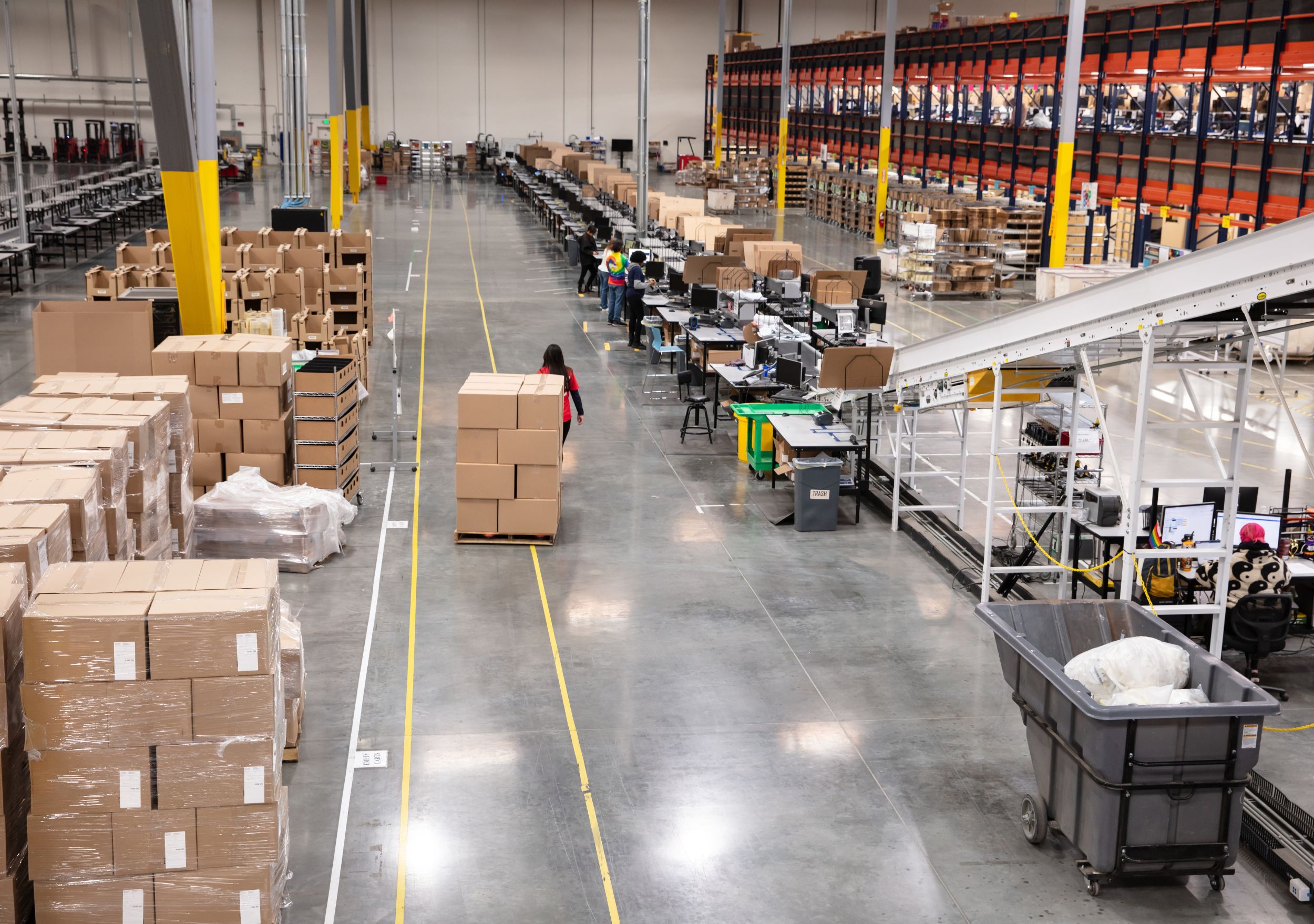 Order fulfilment floor with packing stations and conveyor