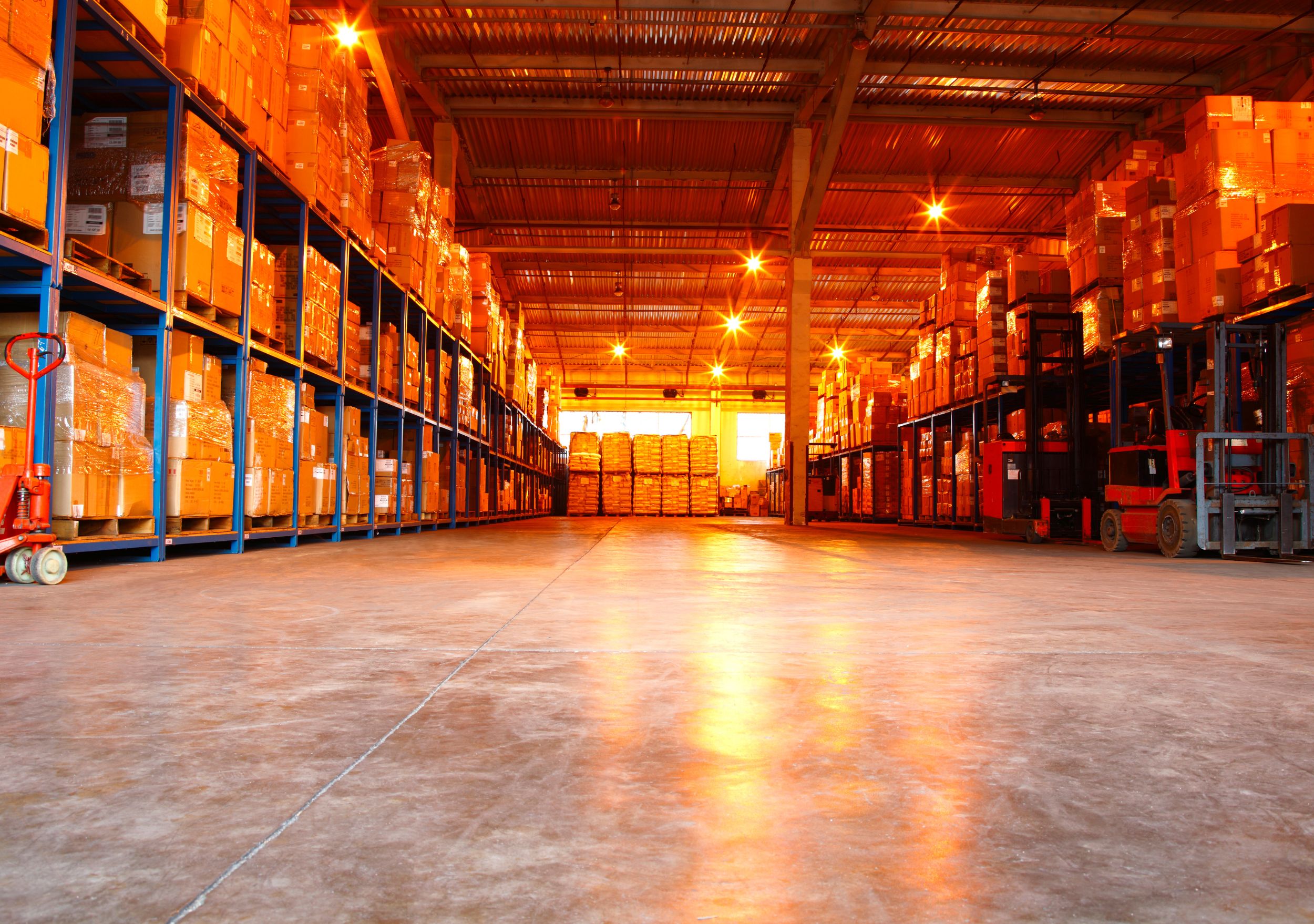 Racked warehouse aisle with forklifts and stored inventory